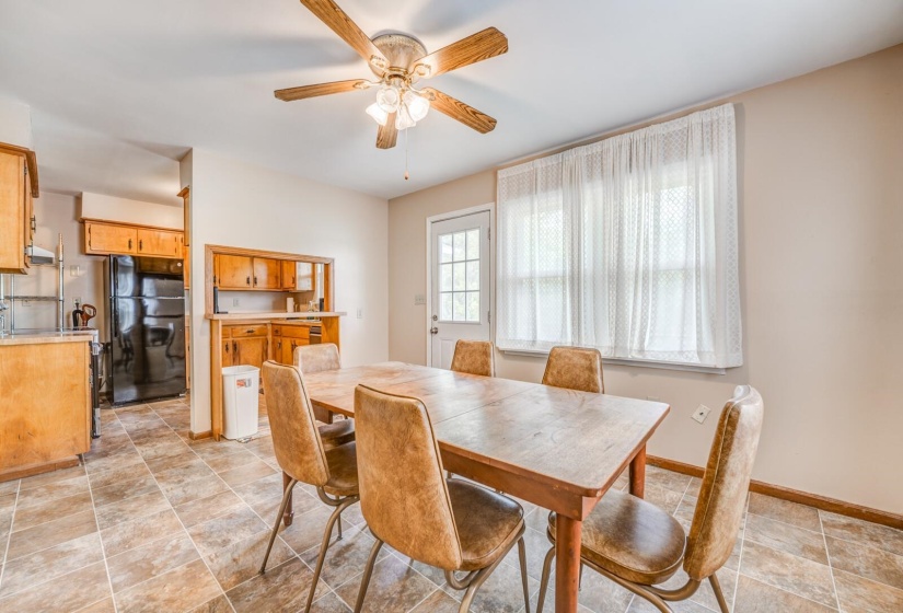 Dining area featuring ceramic tile flooring, a ceiling fan with light fixture, and a white paneled door with window panes