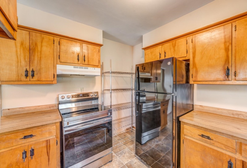 Kitchen featuring light wood cabinetry and wood-finish countertops