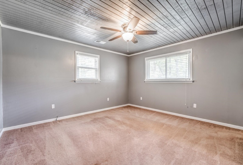 Room featuring a planked ceiling with a ceiling fan, two windows with blinds, light gray wall paint, and carpet flooring