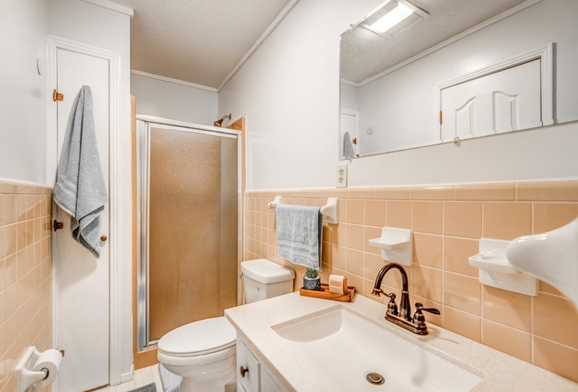 Bathroom featuring a vanity with an integrated sink, a bronze-finish faucet, and a large wall-mounted mirror