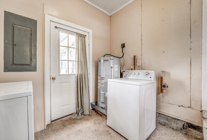 Utility area with light beige walls and light brown carpet flooring