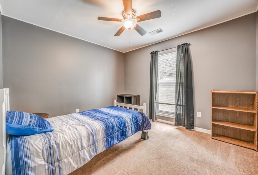Carpeted room featuring a ceiling fan with integrated lighting, a window with blinds, and neutral-toned walls