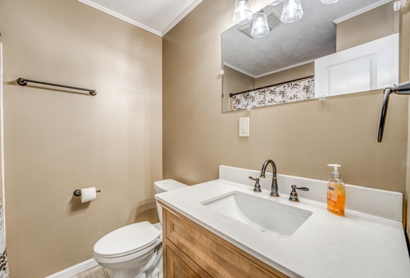 Bathroom featuring a light wood-finish vanity with a white countertop and integrated sink