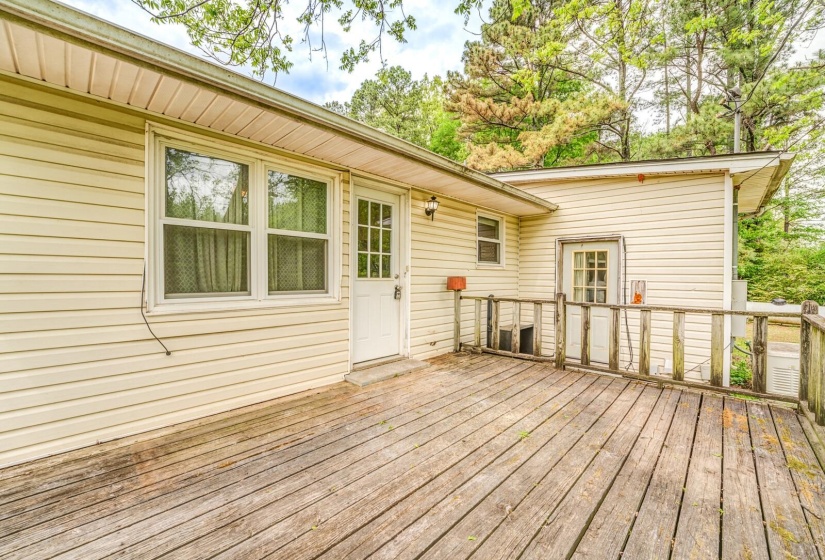 Exterior wood deck with a door and multiple windows, featuring horizontal siding