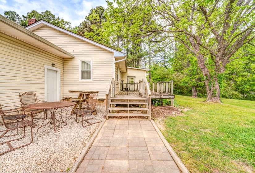 Cream-colored siding exterior featuring a multi-level wooden deck and a paved walkway