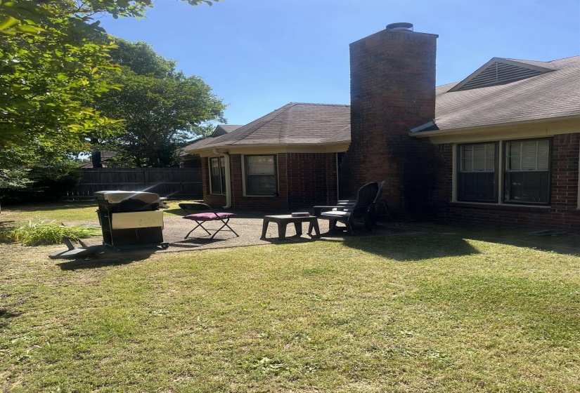 Brick exterior with a prominent chimney and multiple windows