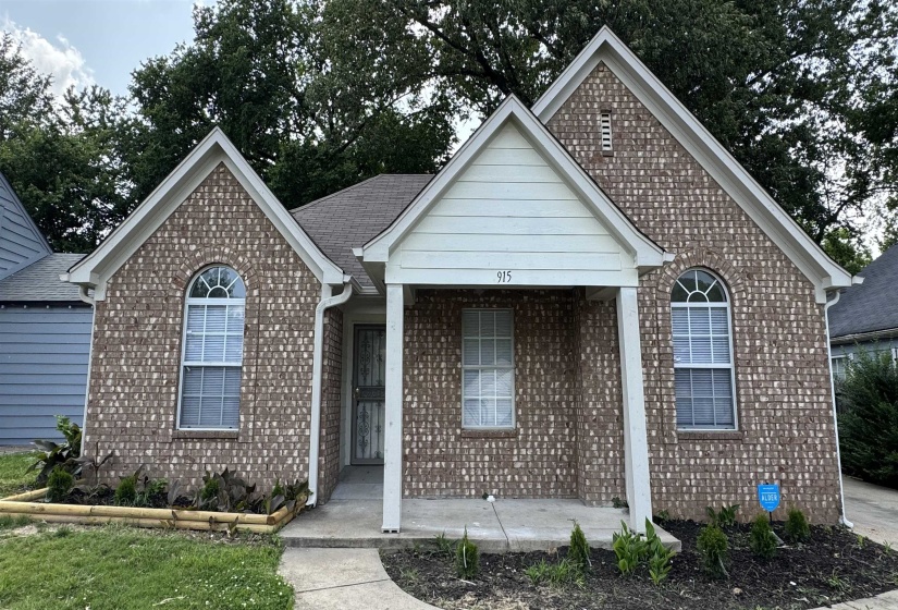 Ranch-style house featuring a porch and brick siding