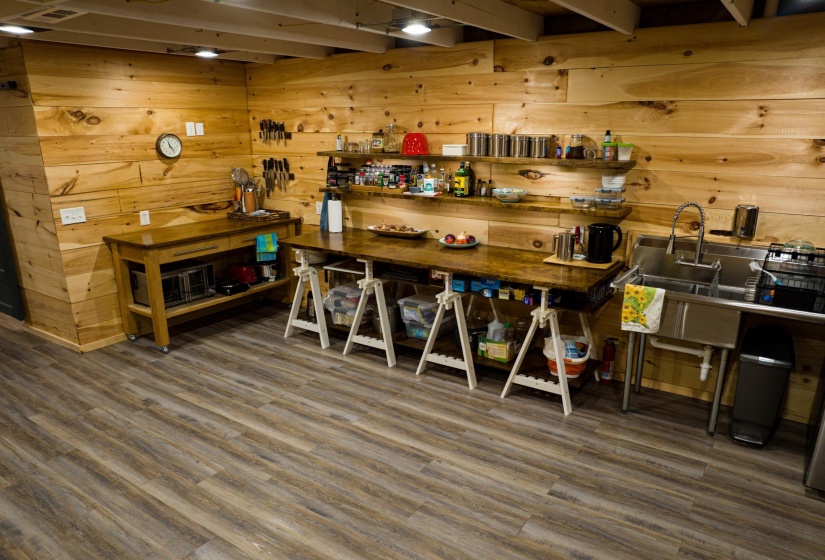 Wood-finish plank flooring complements extensive wood paneling throughout this versatile space
