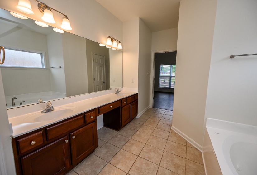 Bathroom featuring a dual vanity with wood cabinetry, light-toned countertops, and two undermount sinks