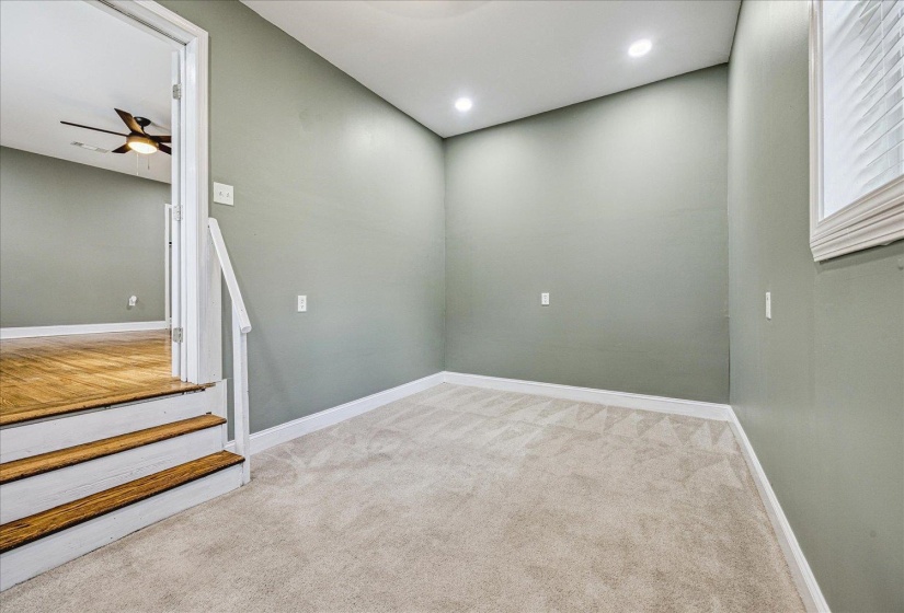 Carpeted room with recessed lighting and a window featuring blinds