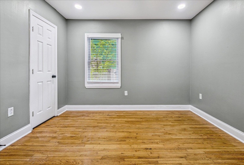 Room featuring light grey walls, wood-finish flooring, and white trim