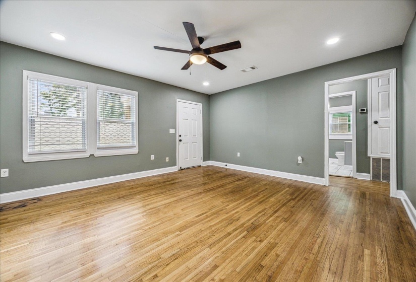 Spacious room featuring wood-finish flooring, recessed lighting, and a ceiling fan