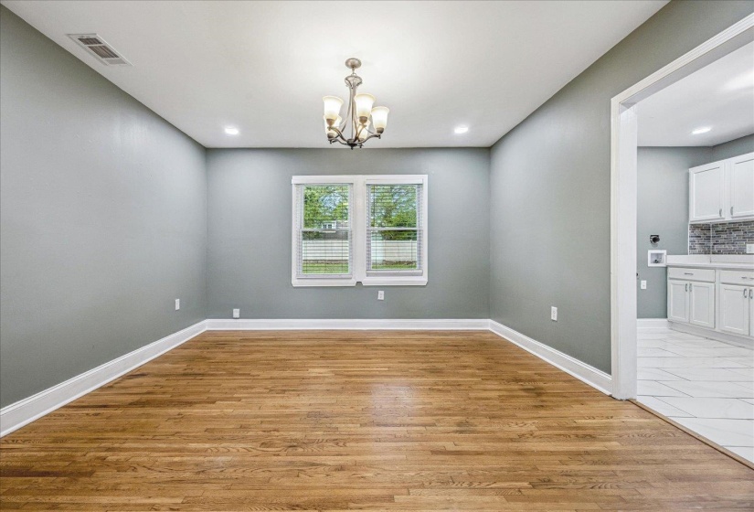 Spacious room featuring wood-finish flooring, light gray walls, and white trim