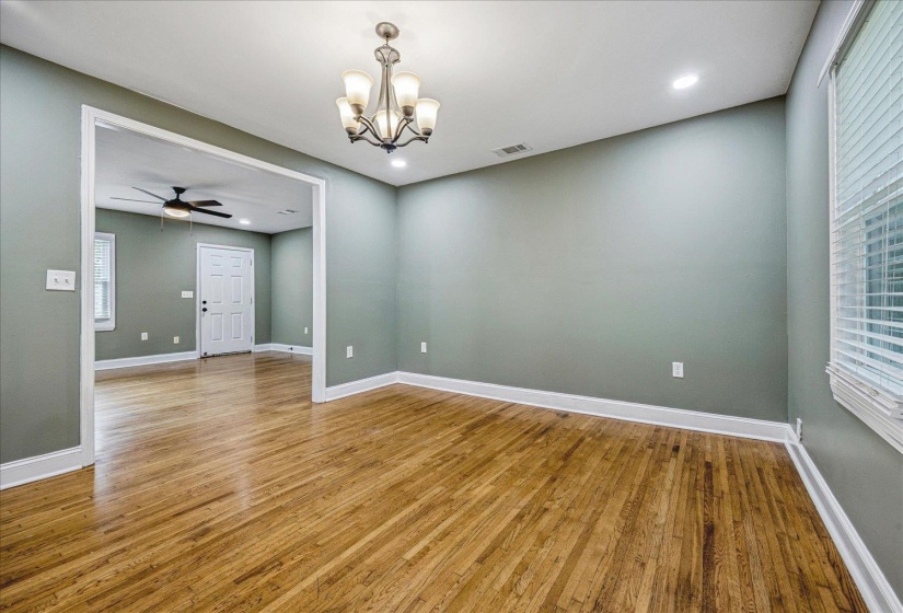 Hardwood-finish flooring throughout, featuring a five-light chandelier and recessed lighting