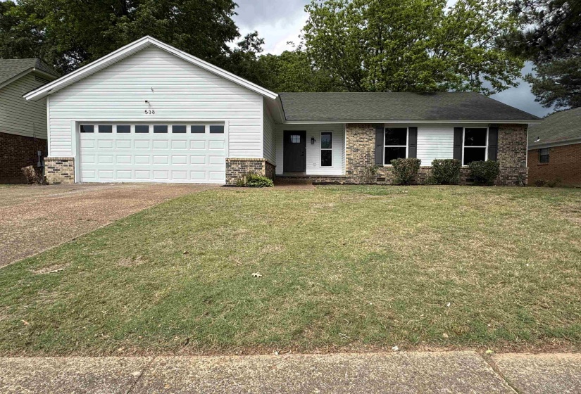 Single-story residence featuring white siding and brick accents