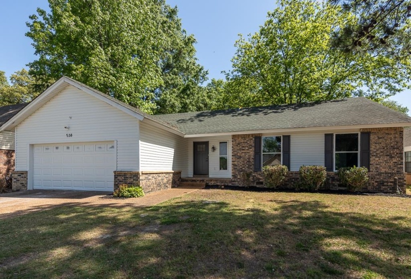 Traditional ranch-style residence featuring white siding and brick veneer accents