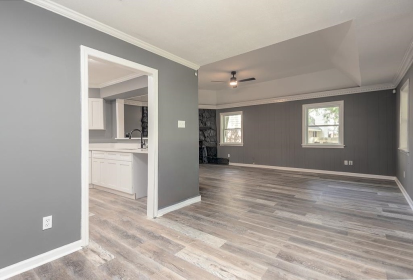 Spacious living area featuring wood-finish flooring, light gray walls, and crown molding
