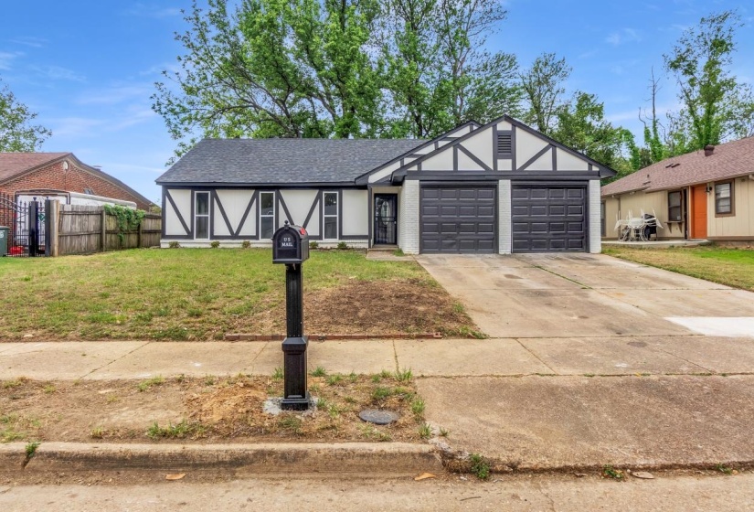 Tudor-style facade featuring white stucco and dark timber detailing