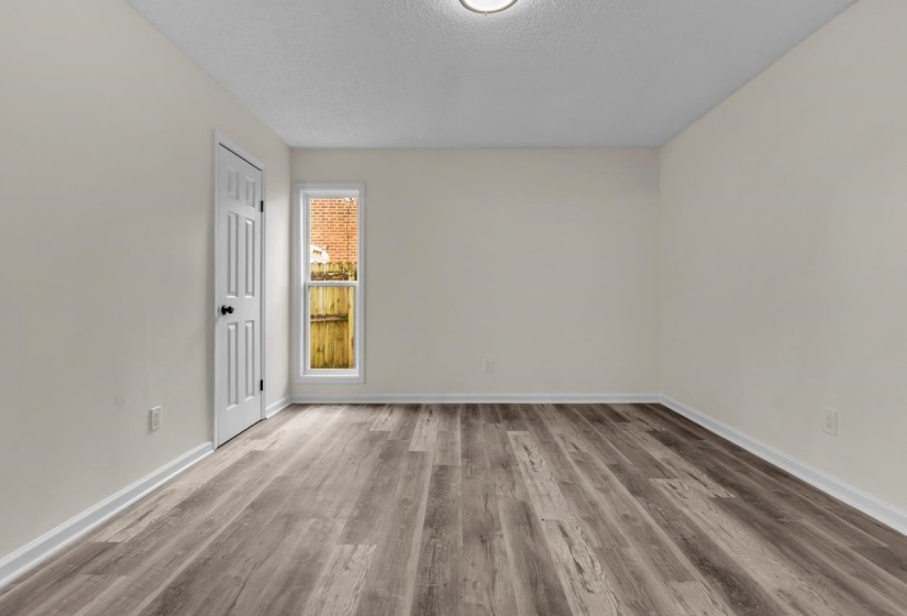 Spacious room featuring wood-finish flooring and a neutral color palette