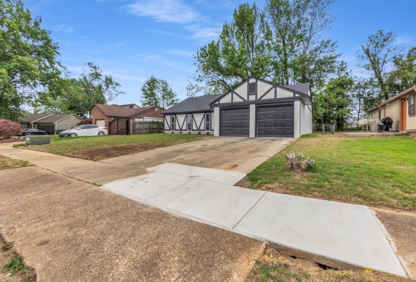 Tudor-style exterior with black and white trim, featuring a two-car garage with dark paneled doors
