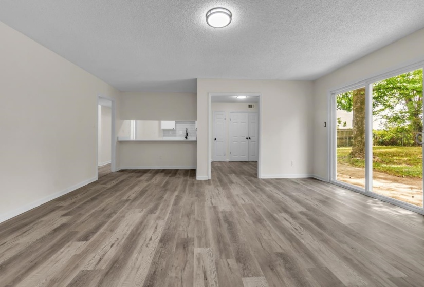 Spacious room featuring wood-finish flooring, white baseboards, and neutral wall tones