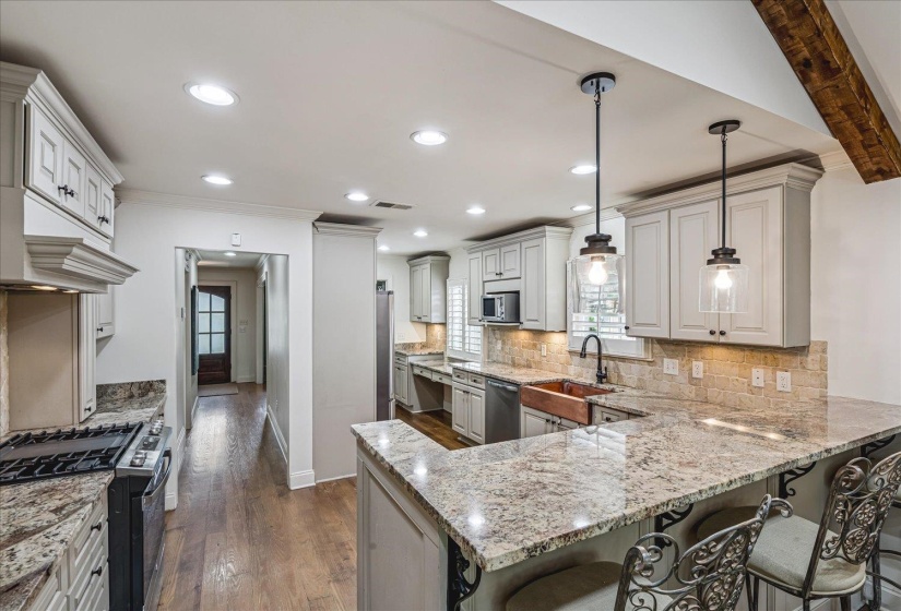 Kitchen featuring granite countertops, a copper basin sink, a gas range, a mosaic tile backsplash, and recessed lighting
