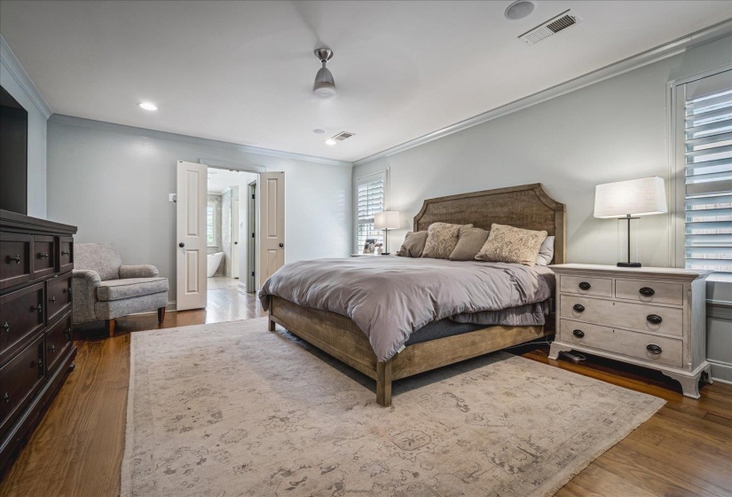 Bedroom featuring wood-finish flooring, plantation shutters, recessed lighting, and a ceiling fan