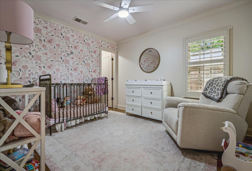 Room featuring a floral accent wall and light-toned carpet flooring
