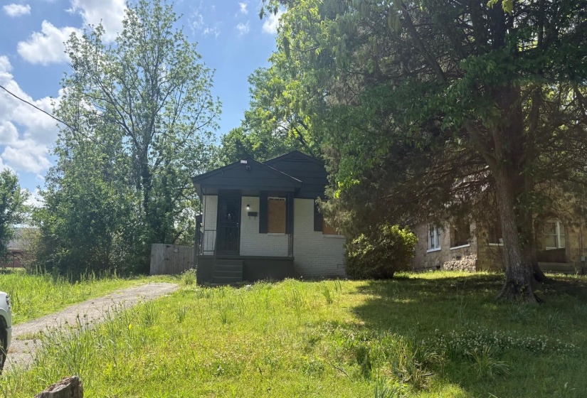 Single-story residence featuring a dark-colored roof and light-toned siding