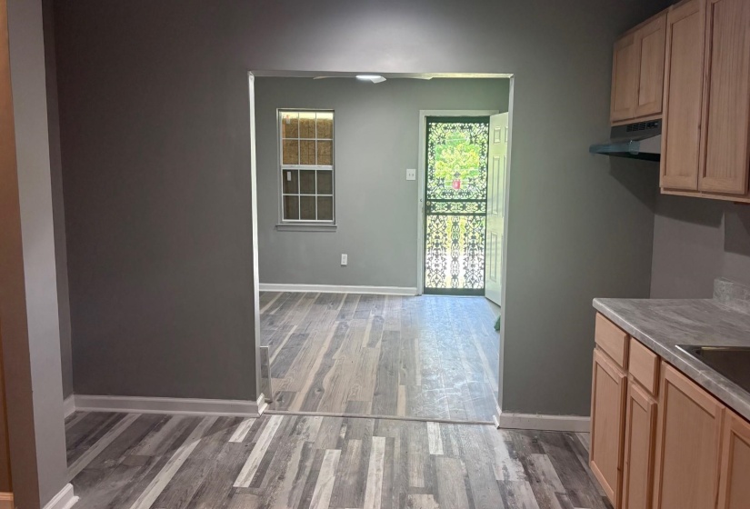 Kitchenette featuring neutral wood-finish cabinetry, a laminate countertop, and a built-in range hood