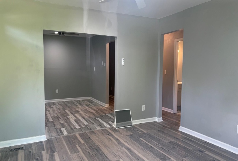 Interconnected living areas featuring consistent wood-finish flooring and a neutral color palette