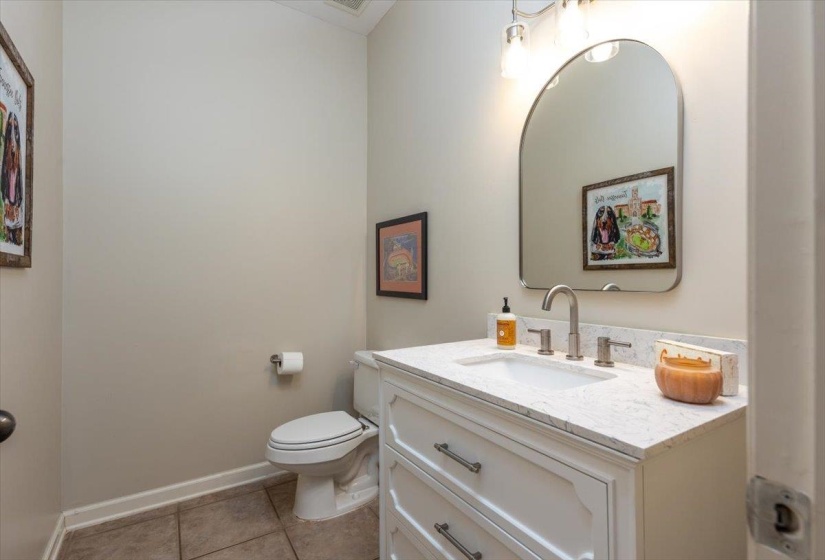 Bathroom featuring a white vanity with a stone-finish countertop, under-mount sink, and brushed nickel fixtures
