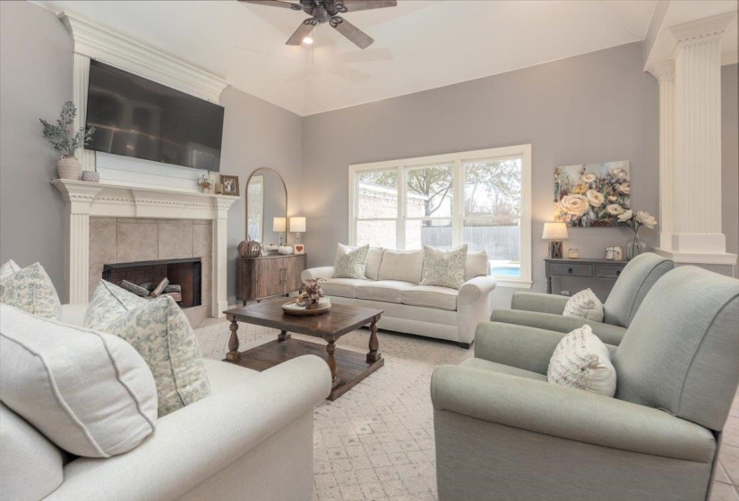 Living area featuring a vaulted ceiling and a fireplace with a detailed mantelpiece