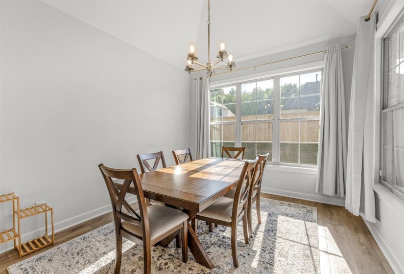 Dining area featuring light wood-finish flooring and a contemporary chandelier