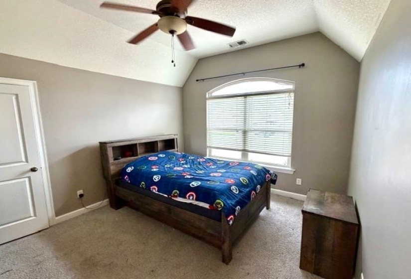 Vaulted ceiling with ceiling fan, arched window with horizontal blinds, neutral wall paint, and carpeted flooring