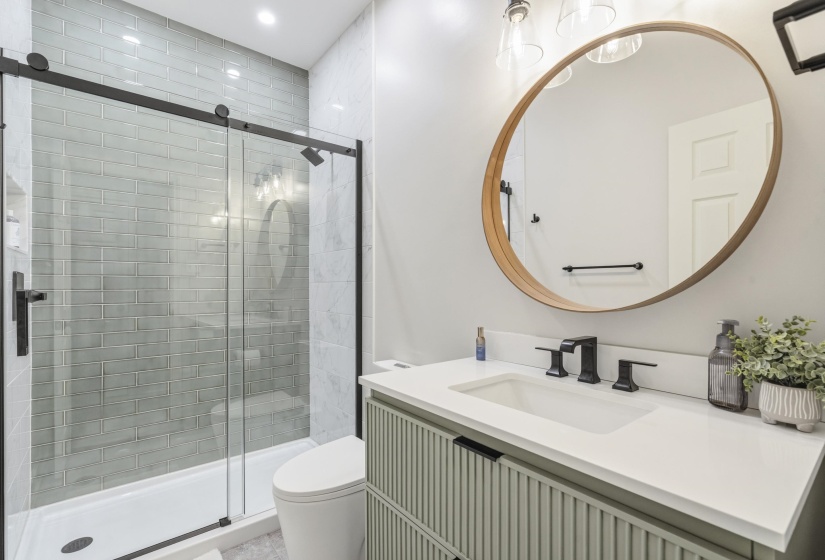 Bathroom featuring a light-toned vanity with textured cabinet fronts, a white countertop with integrated sink, and matte black fixtures