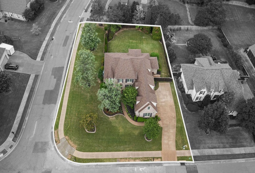 Expansive corner lot featuring a large residence with a multi-gabled roofline
