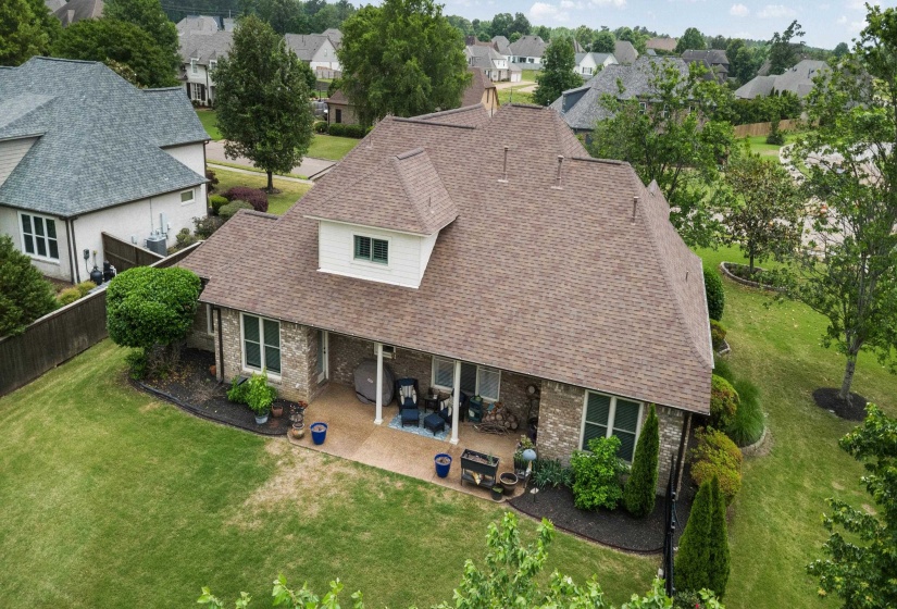Rear exterior featuring a covered patio with columns, brick facade, and a dormer window
