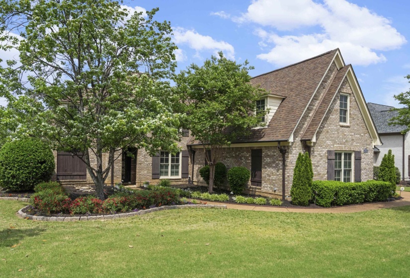 Brick exterior with dormer windows and dark shutters