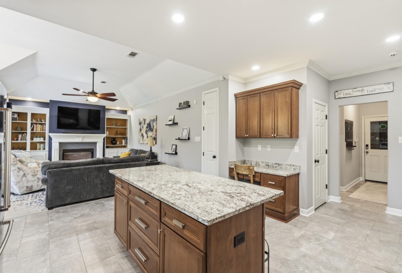 Kitchen island with granite countertop and rich wood cabinetry