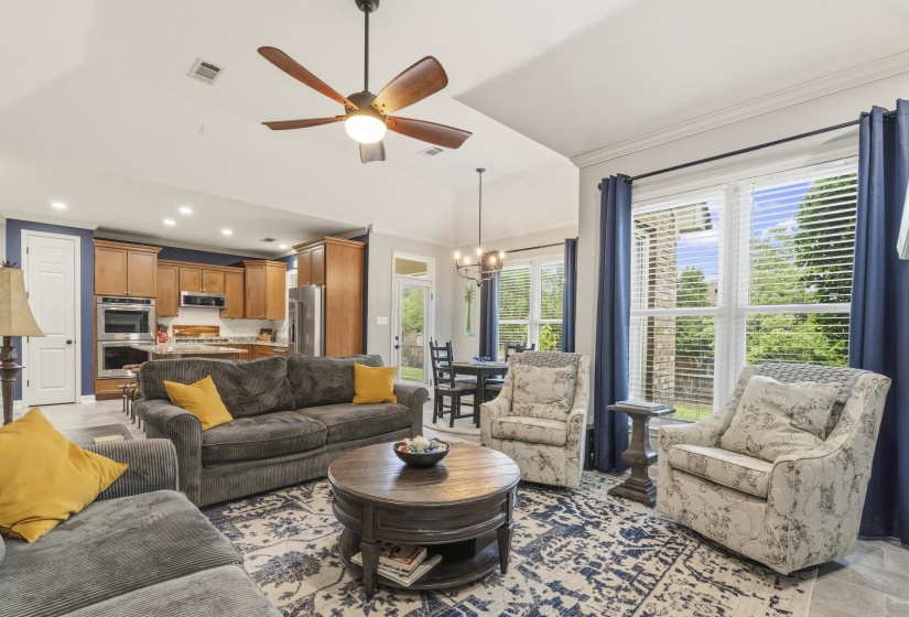 Open-concept living area featuring a vaulted ceiling with a ceiling fan, recessed lighting, and large windows with horizontal blinds