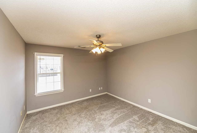 Unfurnished room with light carpet, a textured ceiling, and a ceiling fan