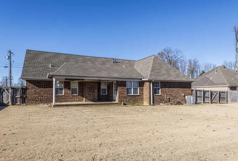 Back of house with brick siding, a patio area, and a shingled roof