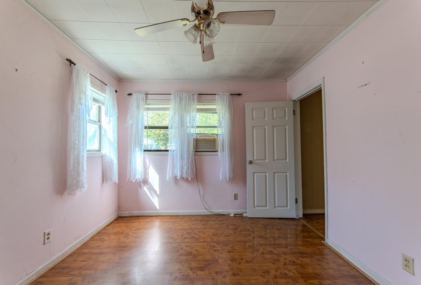 Unfurnished room featuring crown molding, wood finished floors, and a ceiling fan