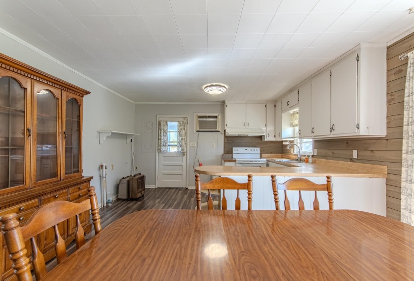 Kitchen with light countertops, plenty of natural light, a peninsula, a kitchen breakfast bar, and ornamental molding