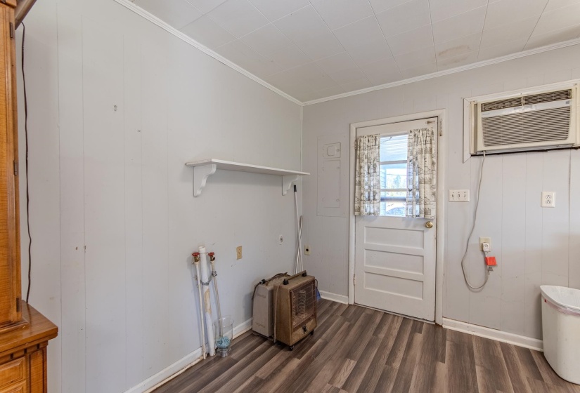 Doorway to outside featuring crown molding, wood finished floors, and a wall mounted AC