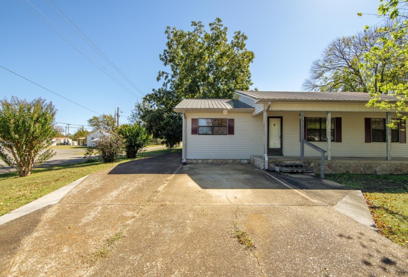 View of front of home with a porch, a metal roof, and a front yard