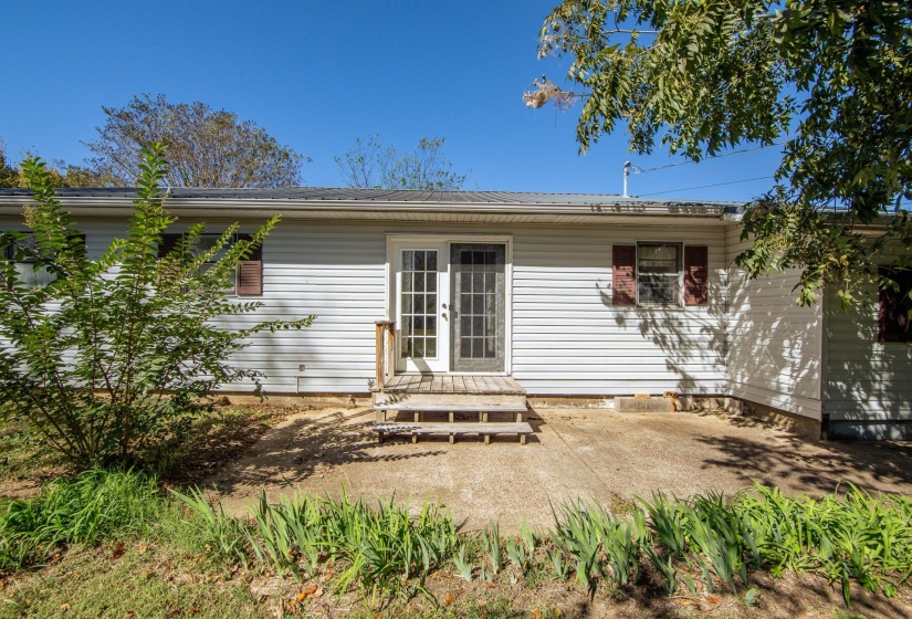 Rear view of house featuring a metal roof and a patio area
