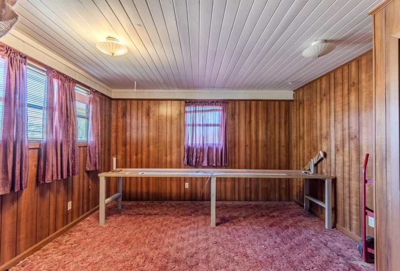 Unfurnished office with wood ceiling, carpet flooring, and wood walls
