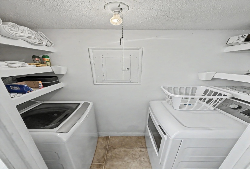 Dedicated laundry area featuring tile flooring and built-in shelving
